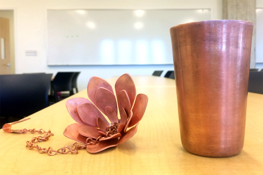 TruePani's antimicrobial water disinfection system uses a thin layer of copper to keep water clean. The cup's design mimics the shape of those typically found in households throughout rural India, and the lotus flower — a symbol of purity in Indian culture — is attached to a chain so it can be placed in the home's water storage container. (Photo: TruePani)