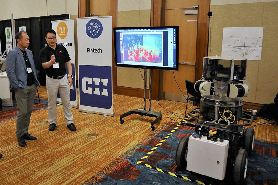 Associate Professor Yong Cho demonstrates some of his robotic technology at a Construction Industry Institute conference. This robot uses lasers and thermal imaging to generate a 3D point-cloud map of a construction site. (Photo Courtesy: Yong Cho)