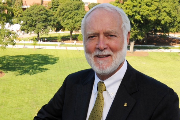 Georgia Tech President Emeritus G. Wayne Clough stands on the roof of his eponymous building with Tech Green and the Student Center in the background.