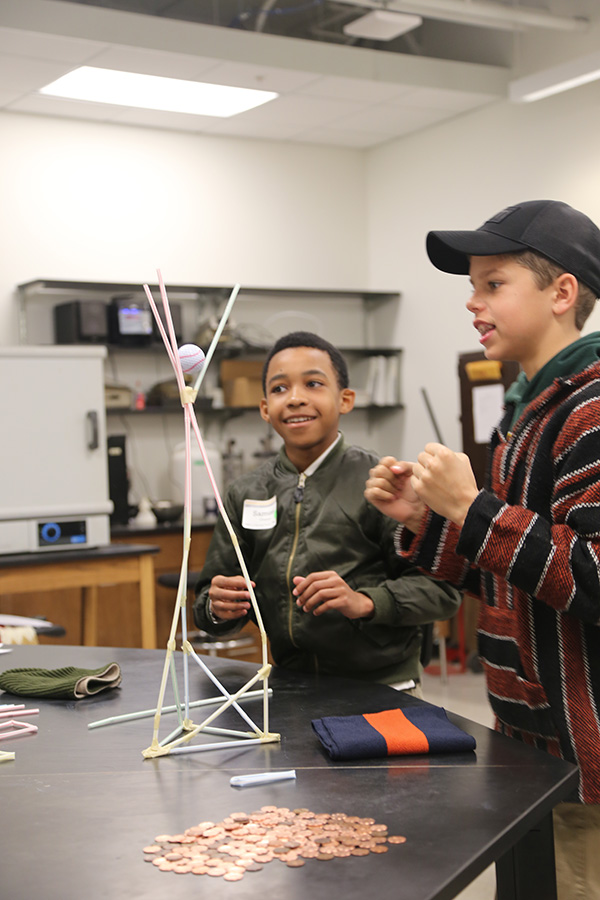 Their other engineering challenge was to build a tower using only drinking straws that was strong enough to hold a golf ball for at least five seconds. Students smile after their tower remained standing for more than five seconds.