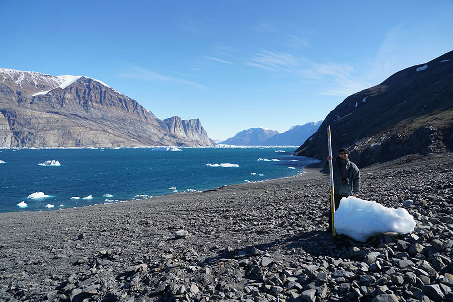 University of Oregon volcanologist Thomas Giachetti stands with an iceberg washed ashore by a landslide-generated tsunami in Greenland in June.