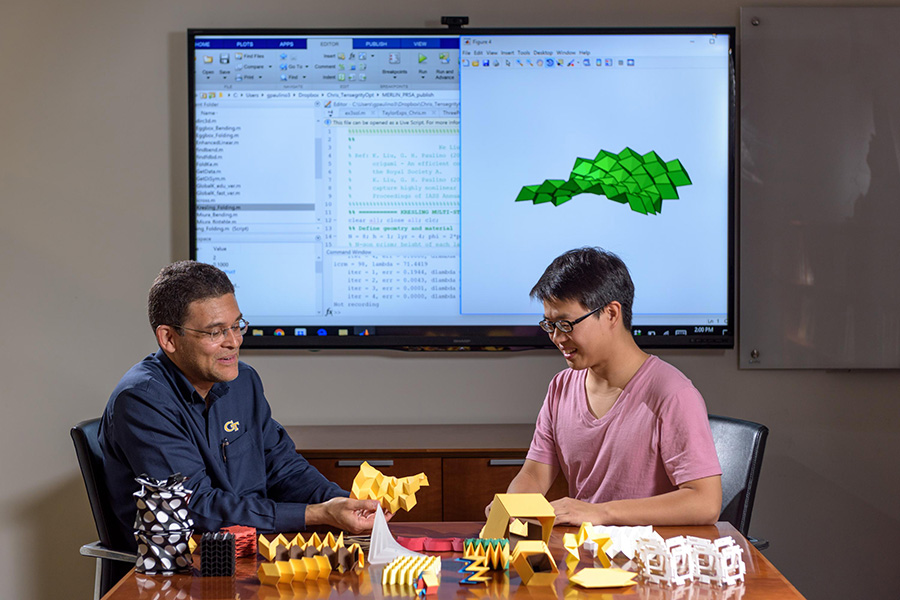 Researchers Glaucio Paulino (left) and Ke Liu with origami structures that can be simulated in new software. (Photo: Rob Felt)
