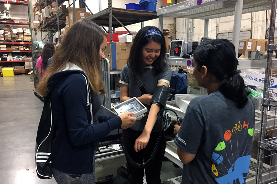 Volunteers with Engineering World Health test a blood-pressure cuff before it is shipped to a community in need.