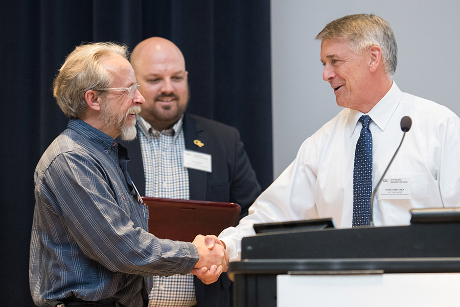Andy Udell, left, accepts the 2018 Building Manager of the Year award at Georgia Tech's Building Manager Symposium March 19 from Mark Demyanek, assistant vice president of facilities operations and maintenance. (Photo: Allison Carter)