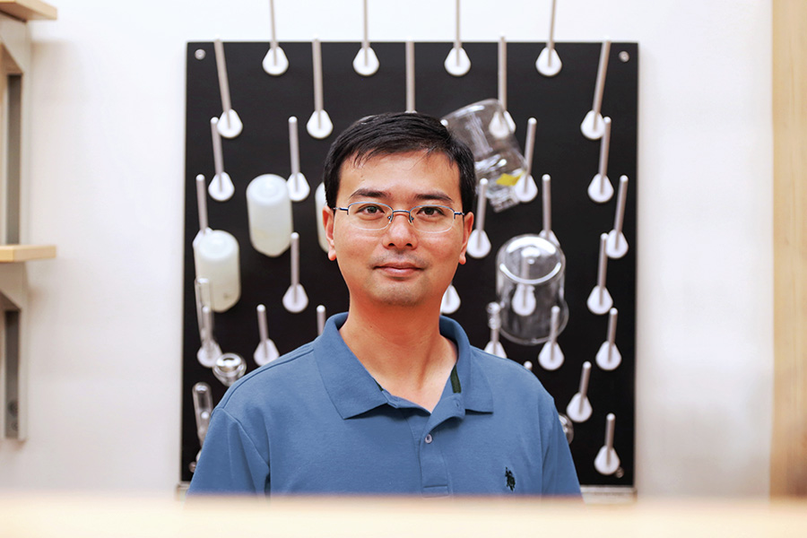 Carlton S. Wilder Assistant Professor Xing Xie in his lab with various beakers hung to dry in the background. (Photo: Jess Hunt-Ralston)