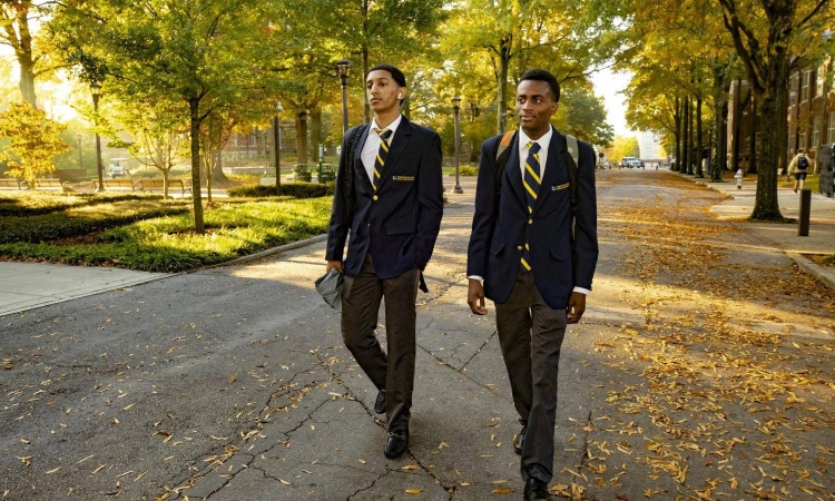 Two young people wearing suits and jackets walk on Georgia Tech campus