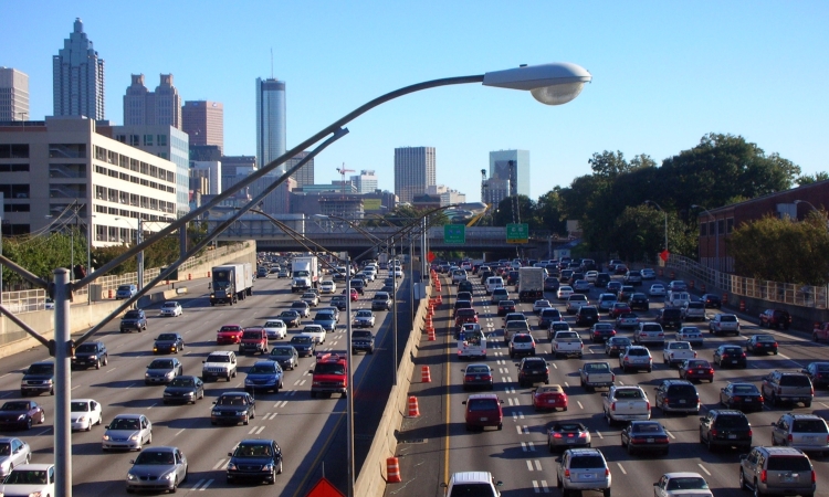 Cars on the a divided highway with the Atlanta skyline in the background
