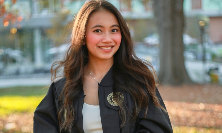 A portrait of a woman in a graduation robe