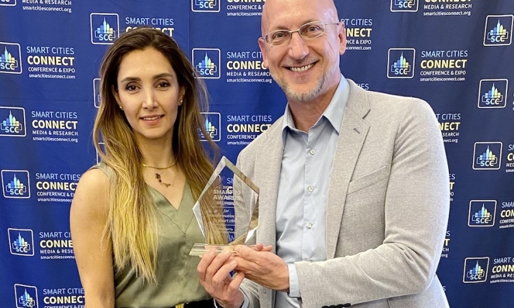 A picture of a man and a woman posing with a glass award