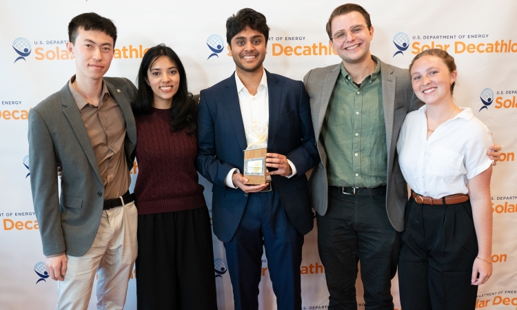 Five students pose with an award