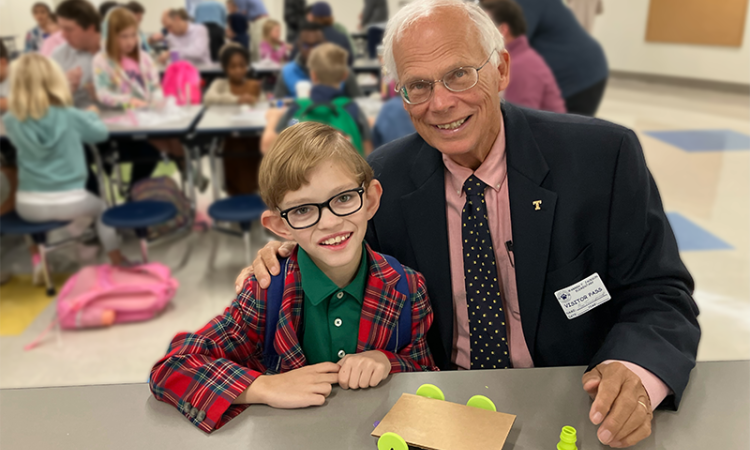 A boy and his grandfather pose together 