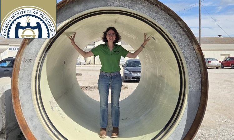 A woman stands in the center of a large section of pipe 