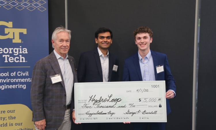 Bill Higginbotham poses with HydroLoop, the team of Anuj Patel, center and Robbie Hauf holding a big check