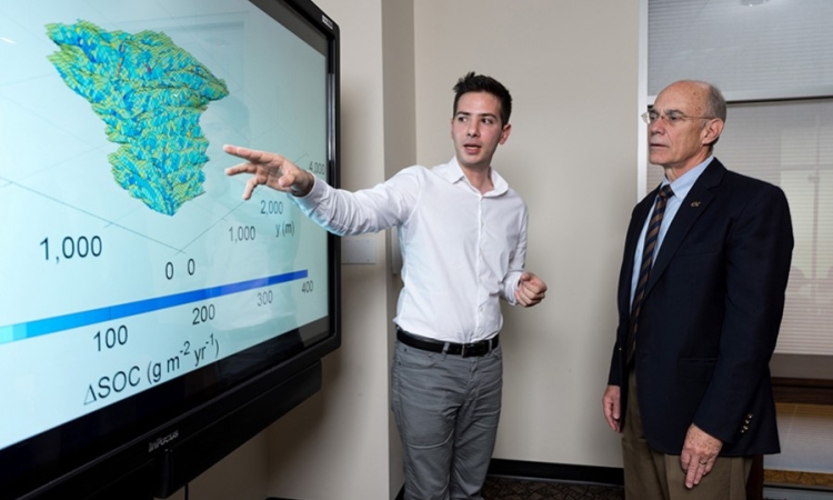Yannis Dialynas, a hydrology Ph.D. student in Georgia Tech’s School of Civil and Environmental Engineering, and Georgia Tech Provost Rafael L. Bras, discuss a model of soil erosion. This research is studying the role of erosion on carbon cycling. (Photo: Rob Felt)