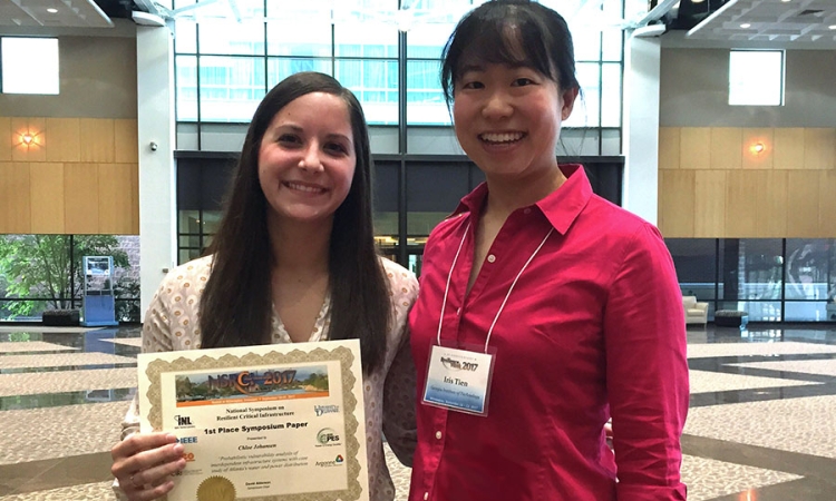 Chloe Johansen, left, and Iris Tien hold their first-place paper award at the Resilience Week 2017 conference for their work analyzing the vulnerabilities of interdependent infrastructure. They used Atlanta's water and power systems as a case study. (Photo Courtesy: Iris Tien)