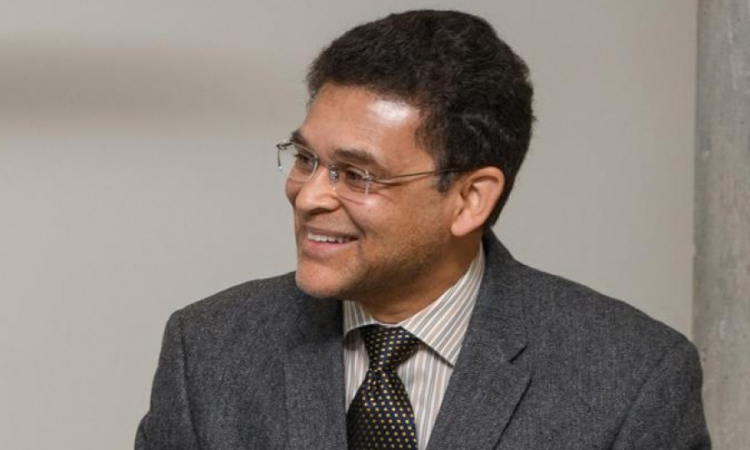 Professor Glaucio Paulino, wearing a gray blazer, smiles as he looks to the left