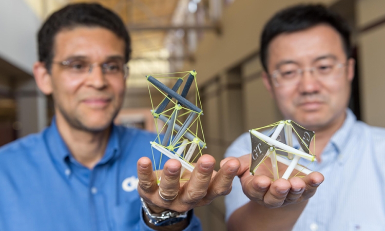 Georgia Tech researchers Glaucio Paulino, left, and Jerry Qi hold 3-D printed objects that use tensegrity, a structural system of floating rods in compression and cables in continuous tension. They’ve developed a new way to create structures with “memory” that can expand dramatically when heated. (Photo: Rob Felt)