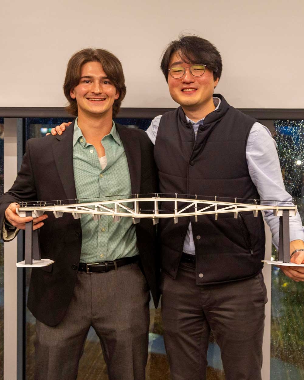 Isaac Wasson and Charles Kim pose holding the model of their winning bridge design