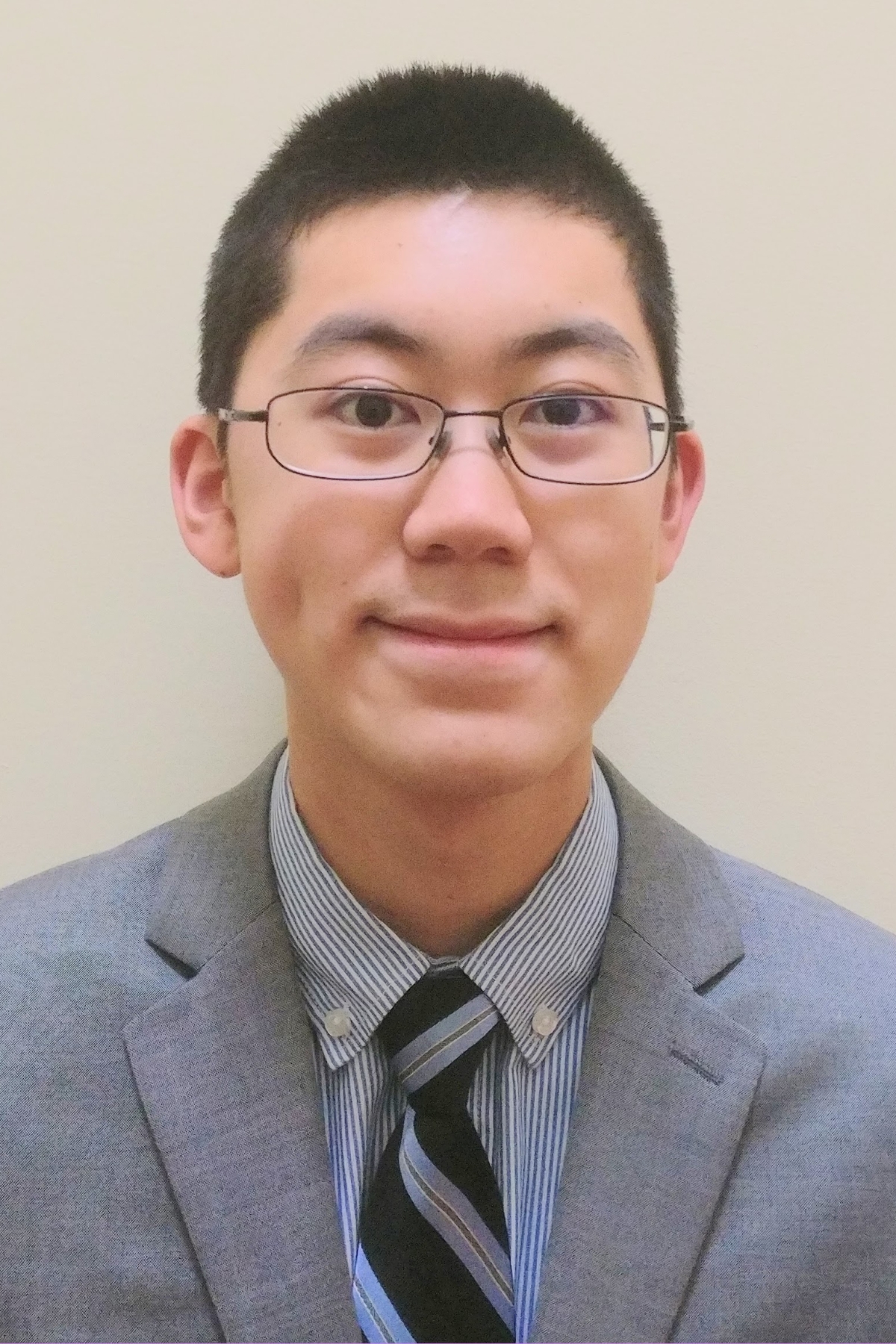 Headshot of man with glasses in front of white wall