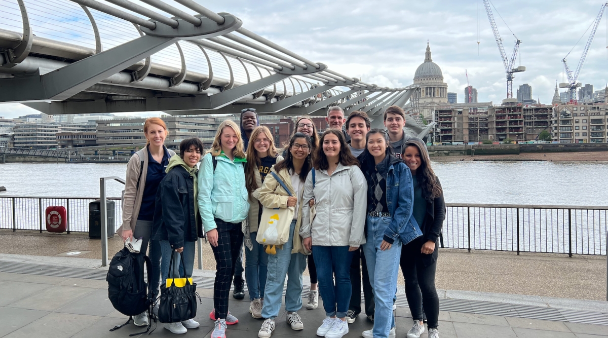 A group posing in front of a bridge