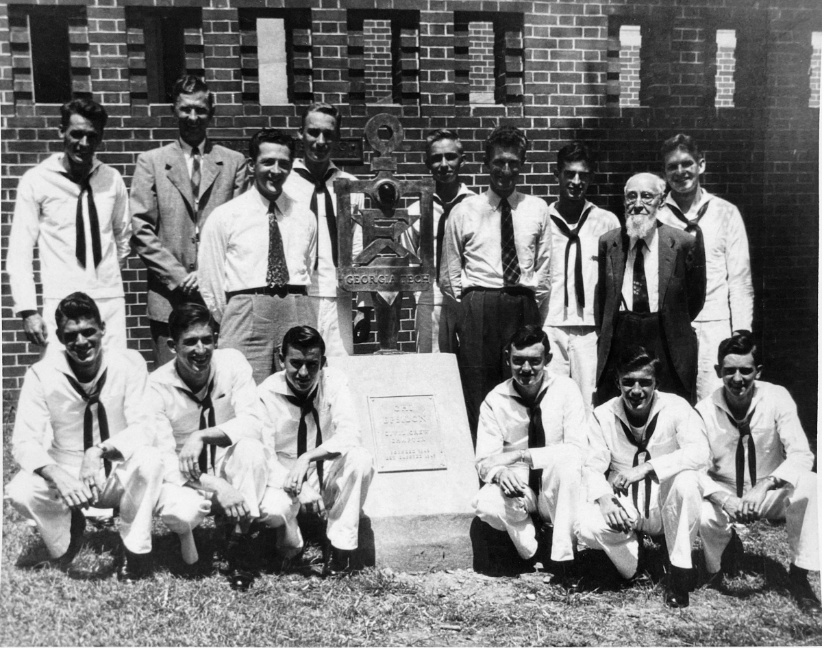 A group photo surrounding the Chi Epsilon monument