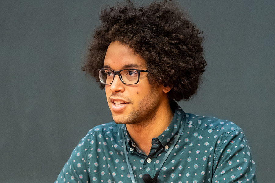 Man in glasses speaks to a crowd