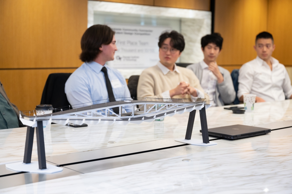 A model of a bridge with people sitting at a conference table