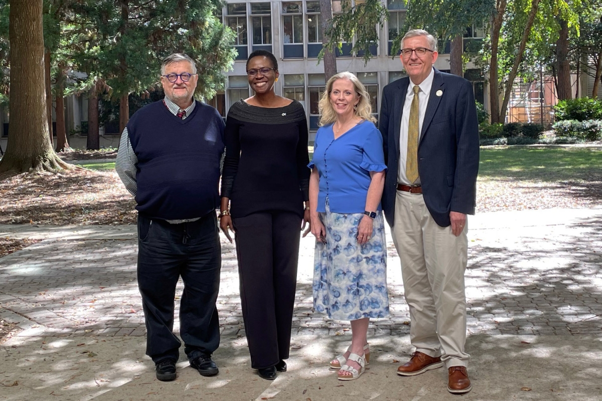 four people standing in a courtyard 