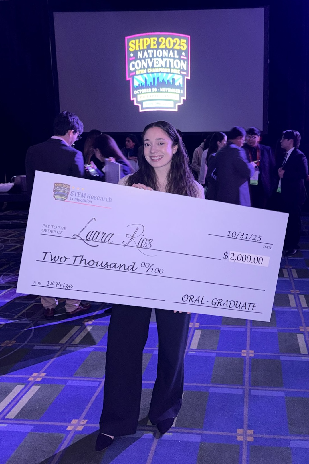 Lara Rios holds an oversized check 