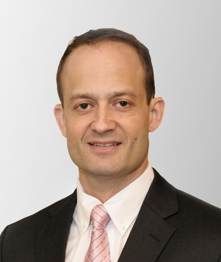 Portrait of Elliot Siegel in a brown blazer and white dress shirt with a pink tie