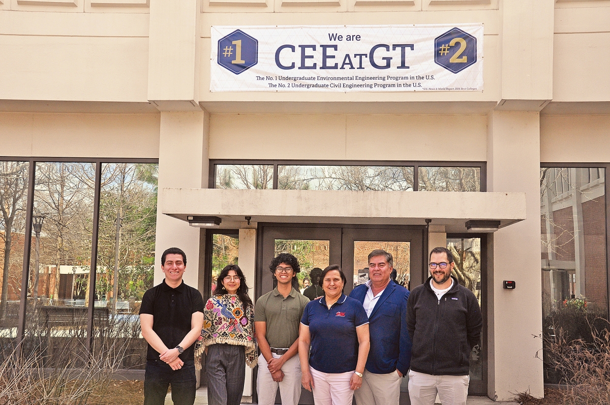 Three students pose with Guiomar Obregón, Carlos Sánchez and Alberto Gomez in front of the Mason building.