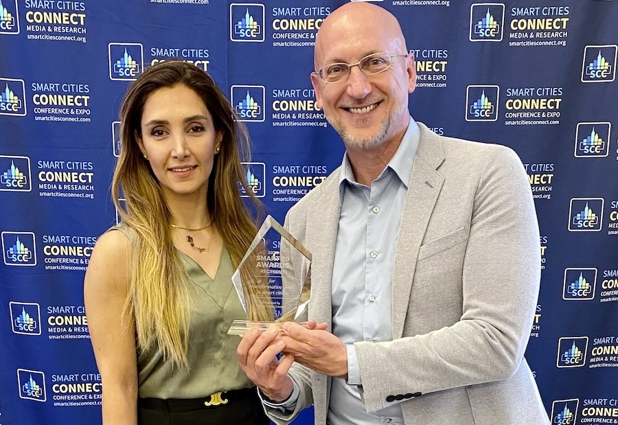 A picture of a man and a woman posing with a glass award