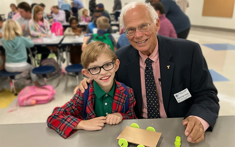 A boy and his grandfather pose together 