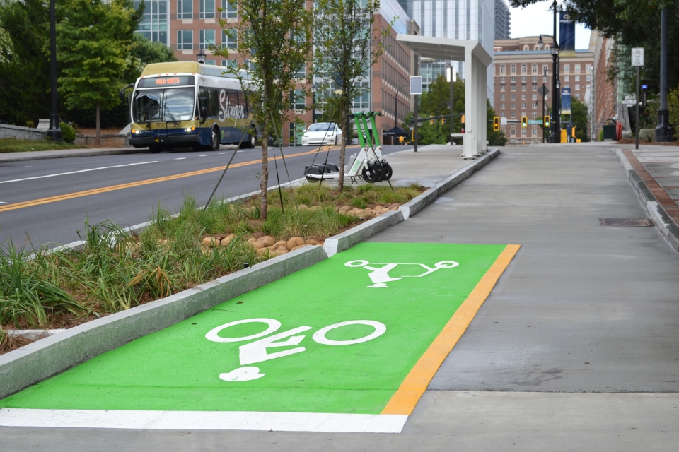 A green cycle track next to a street