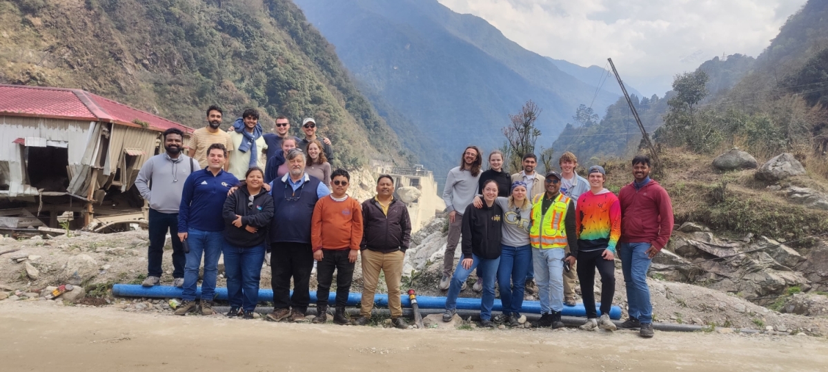 A group poses in front of mountains 