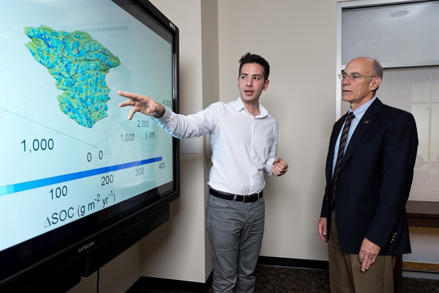 Yannis Dialynas, a hydrology Ph.D. student in Georgia Tech’s School of Civil and Environmental Engineering, and Georgia Tech Provost Rafael L. Bras, discuss a model of soil erosion. This research is studying the role of erosion on carbon cycling. (Photo: Rob Felt)