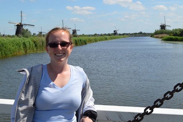 Ph.D. student April Gadsby stands on a bridge over a canal in the Netherlands in 2017 with a few of the country's famed windmills in the background. (Photo Courtesy: April Gadsby)