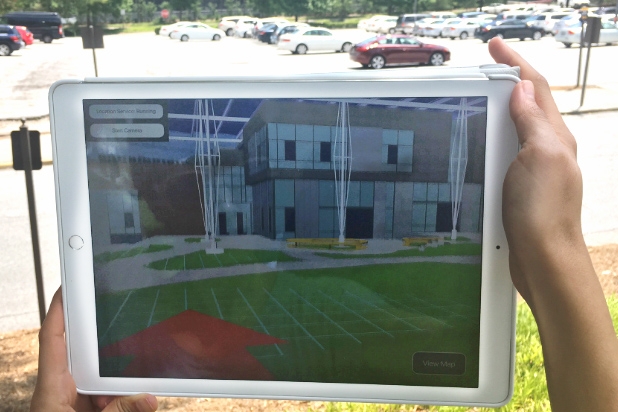 Using an iPad and an augmented reality model like this, students and other future users of Georgia Tech's Living Building will be able to tour the facility long before it opens, offering input on some of the design decisions. A user shows how the model will work at the future site of the building. (Photo Courtesy: Kendeda Fund Living Building Chronicle)