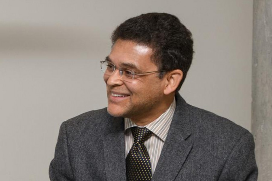 Professor Glaucio Paulino, wearing a gray blazer, smiles as he looks to the left