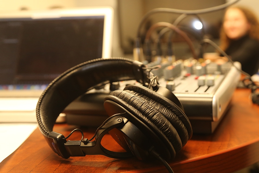 Headphones in front of an audio mixer and laptop during a podcast recording. (Photo: Jess Hunt-Ralston)