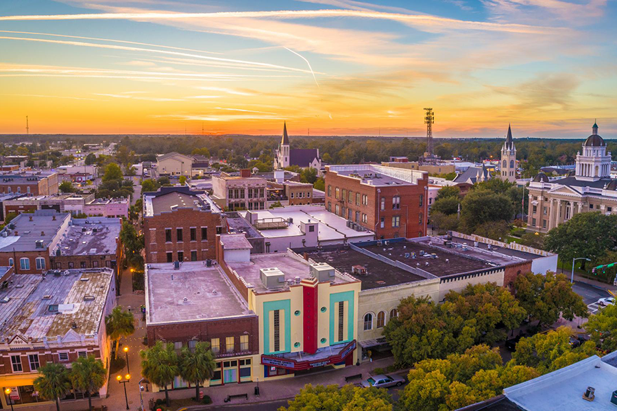 An aerial photo of buildings against a sky at sunset