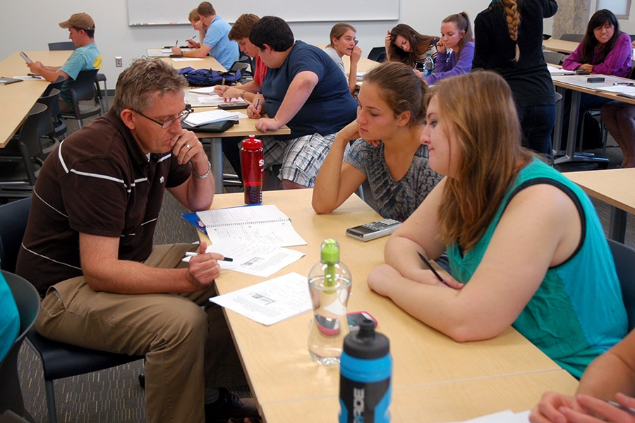 Professor Donald Webster working with students on a problem.
