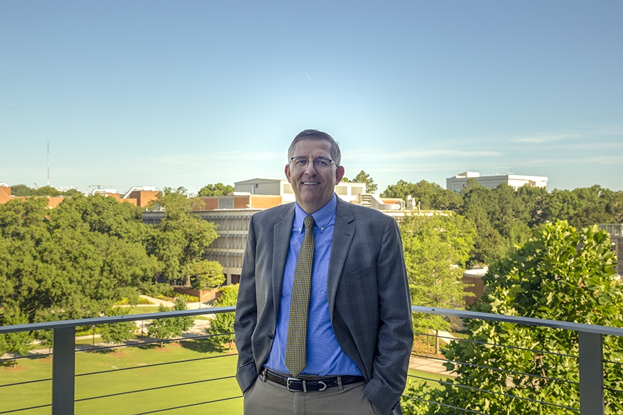 Donald Webster, Karen and John Huff Chair of the School of Civil and Environmental Engineering, poses with Tech Green in the background.