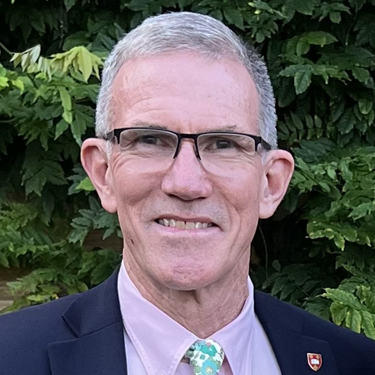 Portrait of Fred Meyer in a blue suit with a lavender shirt and a floral necktie