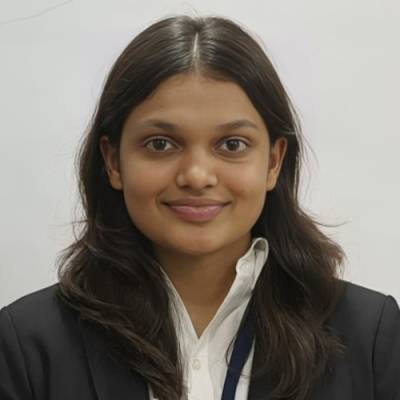 Portrait of Shubhangi Desai wearing a white oxford shirt and a navy blazer